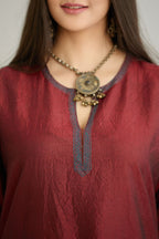 Maroon hand crushed silk kurta set with contrast silk fabric applique work at hem, side slits and sleeves with an embroidered neckline.