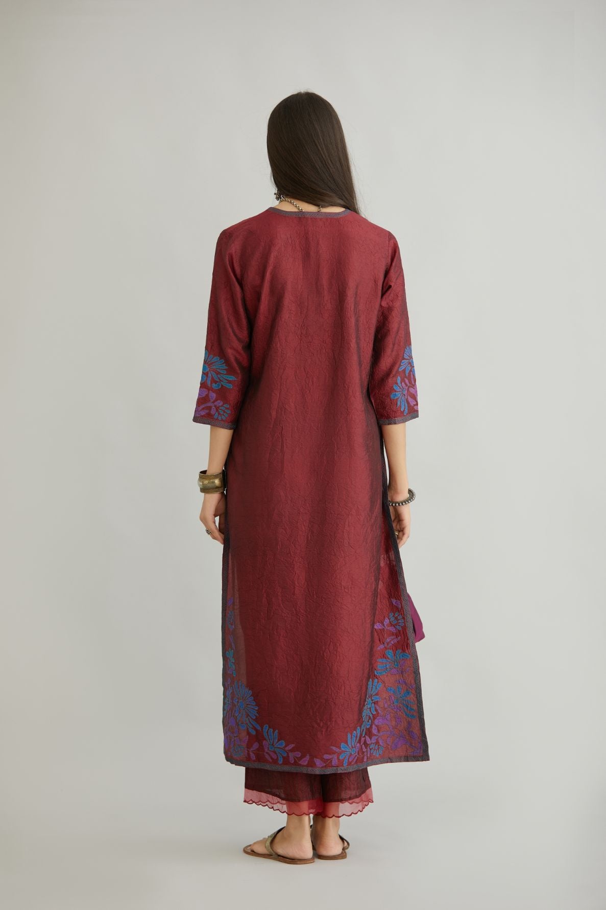 Maroon hand crushed silk kurta set with contrast silk fabric applique work at hem, side slits and sleeves with an embroidered neckline.