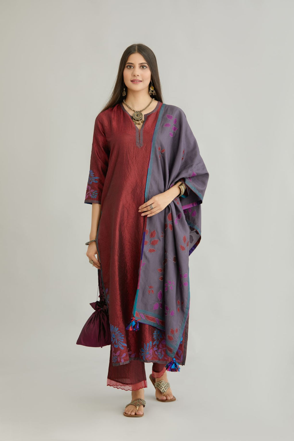 Maroon hand crushed silk kurta set with contrast silk fabric applique work at hem, side slits and sleeves with an embroidered neckline.
