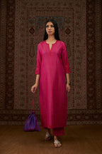Fuchsia hand crushed silk kurta set with contrast silk fabric applique work at hem, side slits and sleeves with an embroidered neckline.