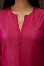 Fuchsia hand crushed silk kurta set with contrast silk fabric applique work at hem, side slits and sleeves with an embroidered neckline.
