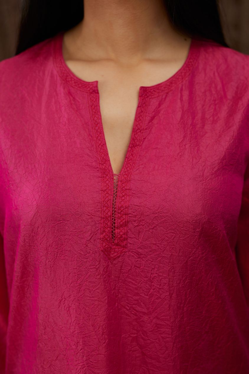 Fuchsia hand crushed silk kurta set with contrast silk fabric applique work at hem, side slits and sleeves with an embroidered neckline.