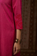Fuchsia hand crushed silk kurta set with contrast silk fabric applique work at hem, side slits and sleeves with an embroidered neckline.