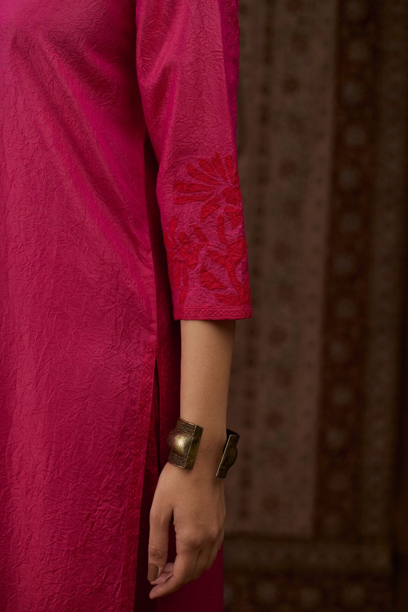 Fuchsia hand crushed silk kurta set with contrast silk fabric applique work at hem, side slits and sleeves with an embroidered neckline.