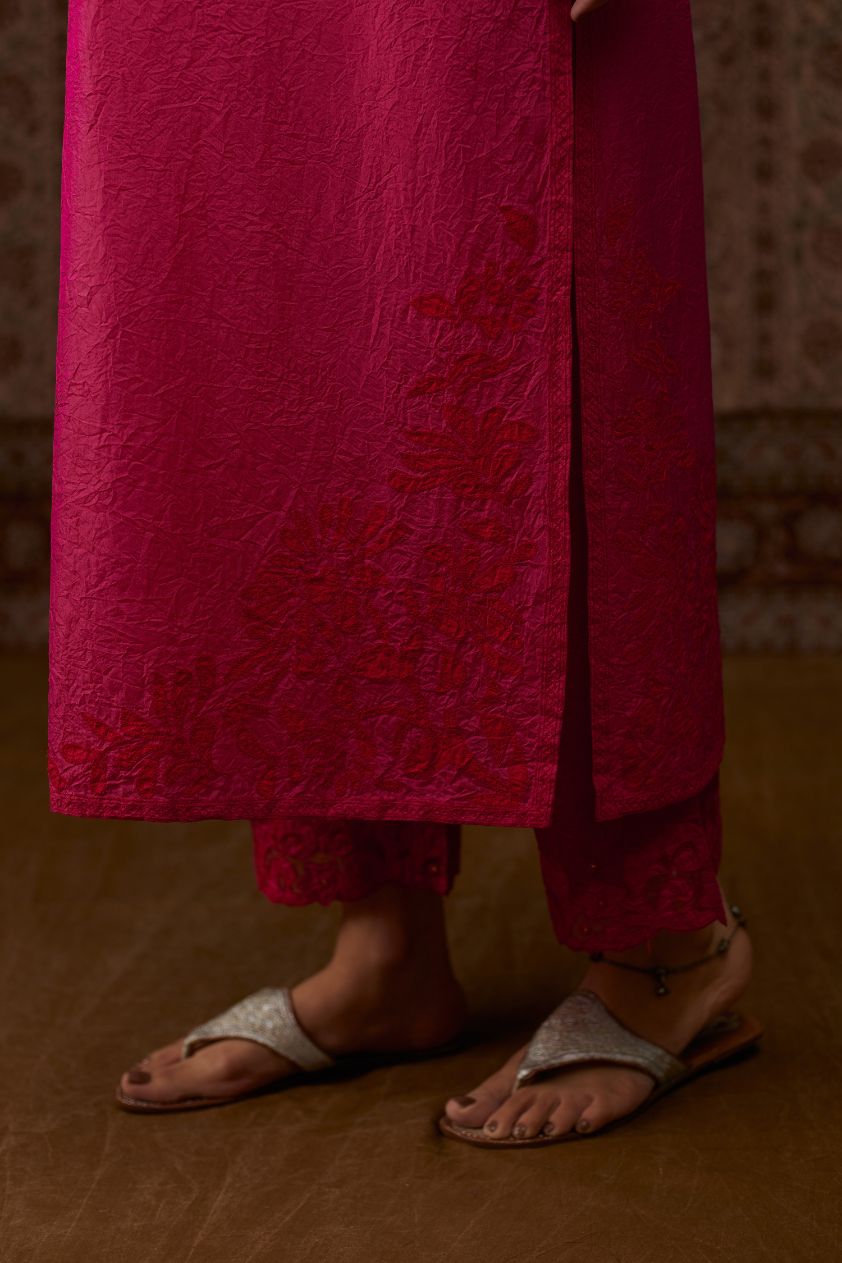 Fuchsia hand crushed silk kurta set with contrast silk fabric applique work at hem, side slits and sleeves with an embroidered neckline.