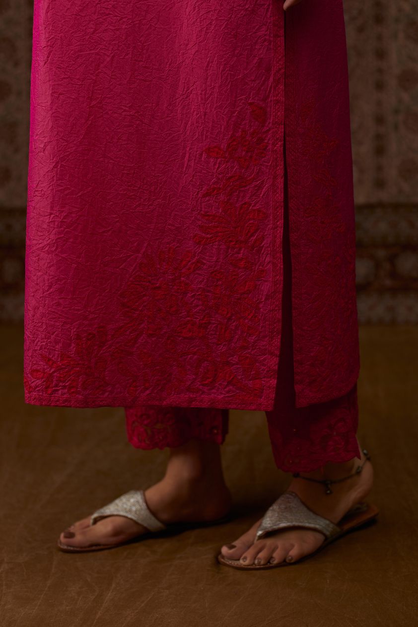 Fuchsia hand crushed silk kurta set with contrast silk fabric applique work at hem, side slits and sleeves with an embroidered neckline.