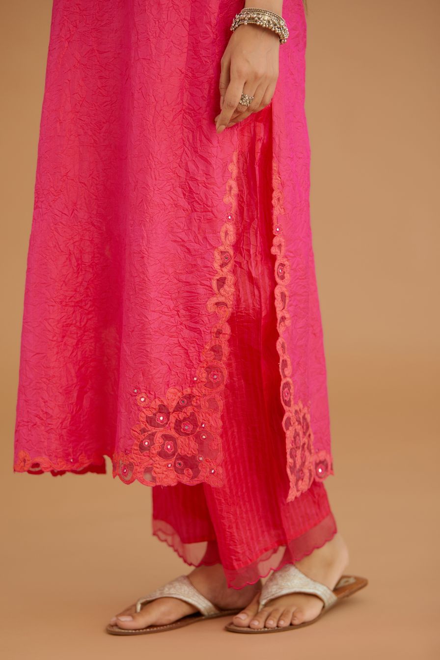 Fuchsia hand crushed silk straight kurta set with silk and organza cutwork embroidery, highlighted with hand attached mirrors.