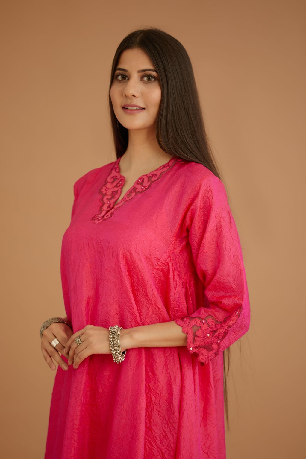 Fuchsia hand crushed silk kurta set with cutwork embroidered asymmetric hem, highlighted with hand attached mirrors.