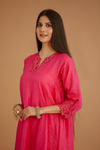 Fuchsia hand crushed silk kurta set with cutwork embroidered asymmetric hem, highlighted with hand attached mirrors.