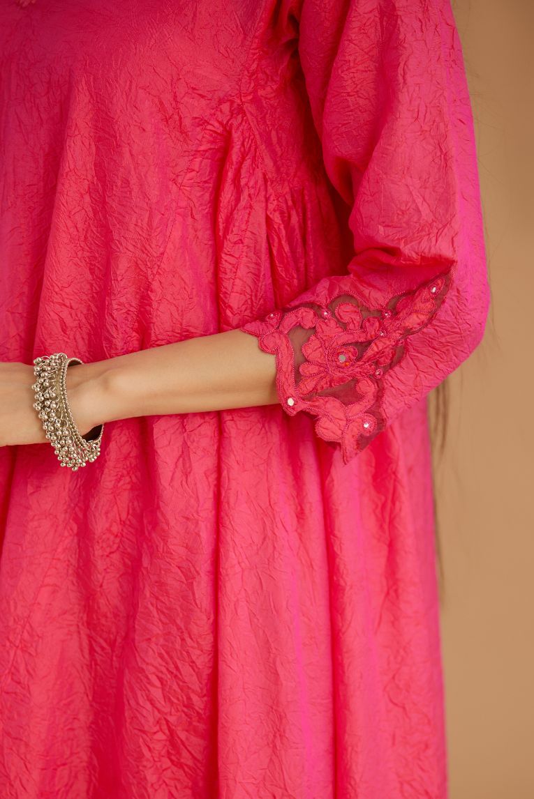 Fuchsia hand crushed silk kurta set with cutwork embroidered asymmetric hem, highlighted with hand attached mirrors.