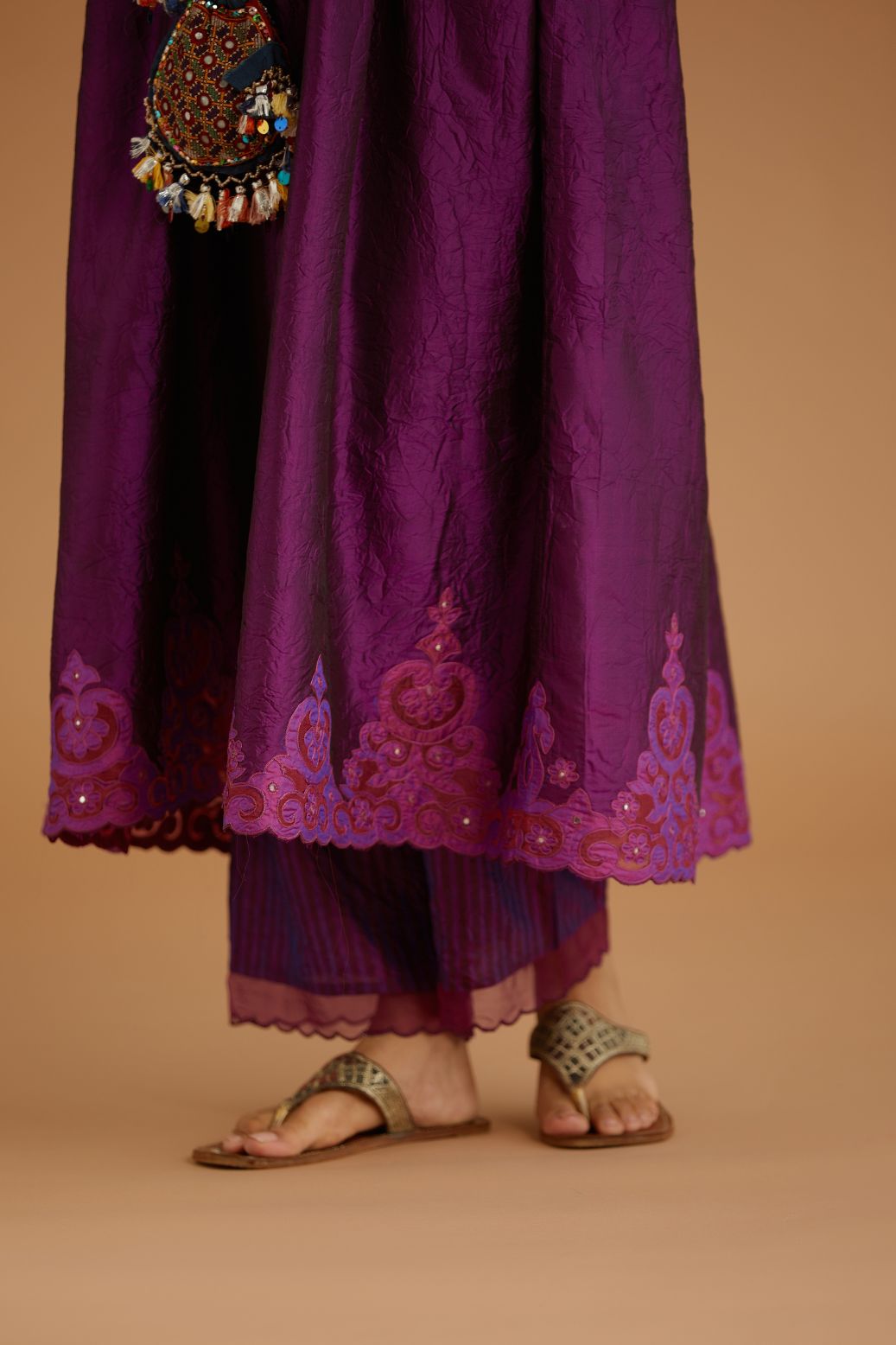 Purple hand crushed silk kurta set with wavy empire waistline and gathers, with silk and organza cutwork embroidery, highlighted with hand attached mirrors.