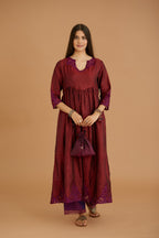 Maroon hand crushed silk kurta set with wavy empire waistline and gathers, with silk and organza cutwork embroidery, highlighted with hand attached mirrors.