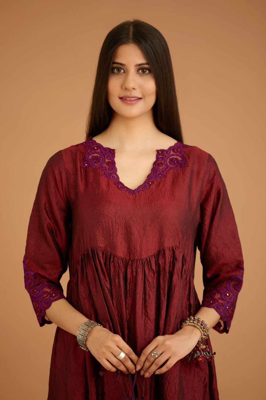 Maroon hand crushed silk kurta set with wavy empire waistline and gathers, with silk and organza cutwork embroidery, highlighted with hand attached mirrors.