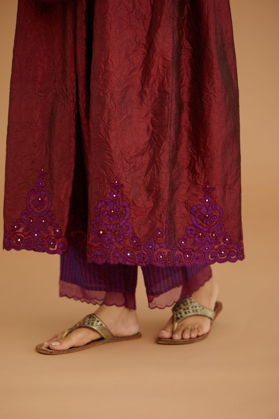 Maroon hand crushed silk kurta set with wavy empire waistline and gathers, with silk and organza cutwork embroidery, highlighted with hand attached mirrors.