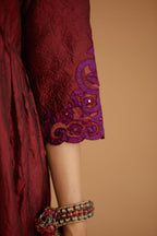 Maroon hand crushed silk kurta set with wavy empire waistline and gathers, with silk and organza cutwork embroidery, highlighted with hand attached mirrors.