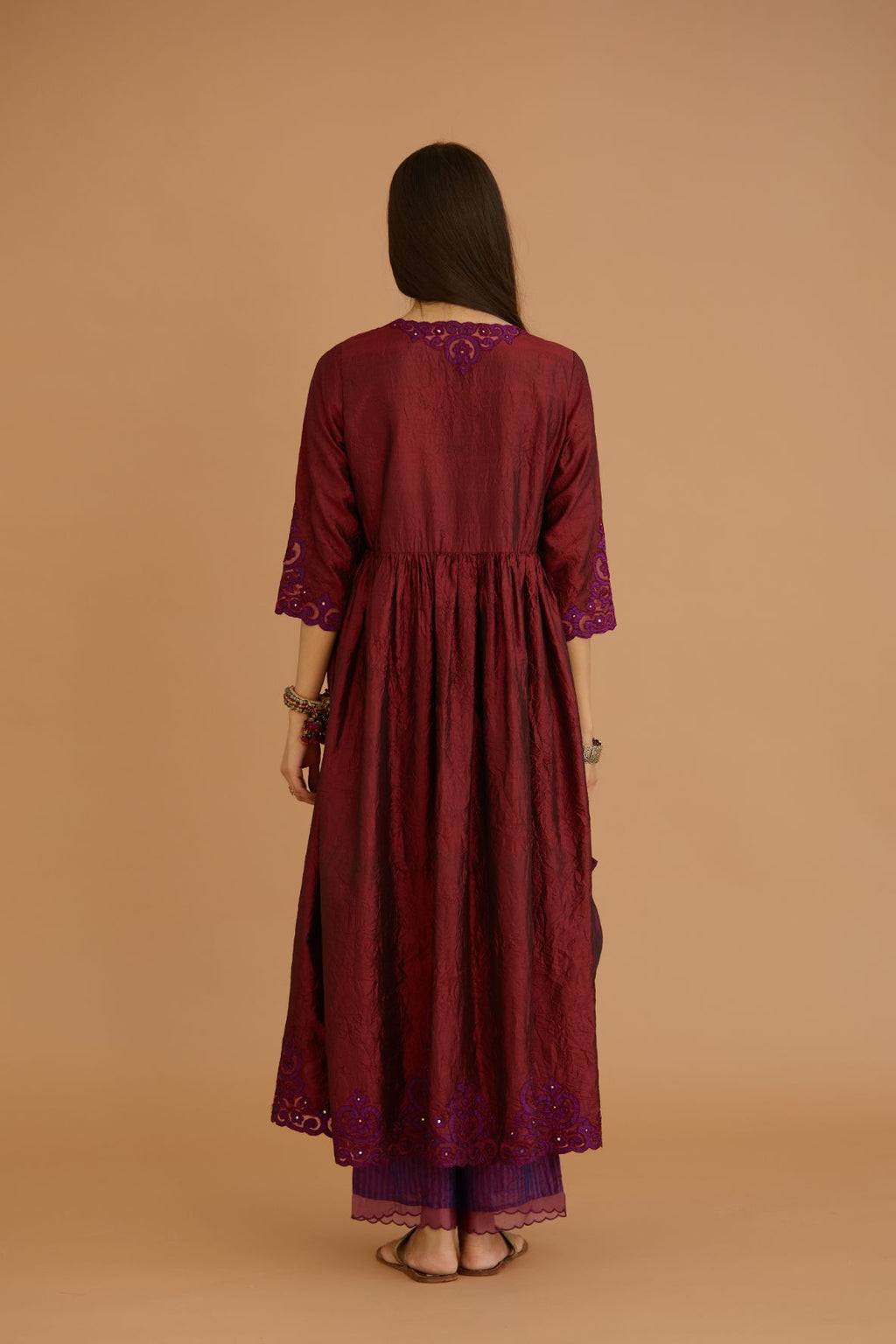 Maroon hand crushed silk kurta set with wavy empire waistline and gathers, with silk and organza cutwork embroidery, highlighted with hand attached mirrors.