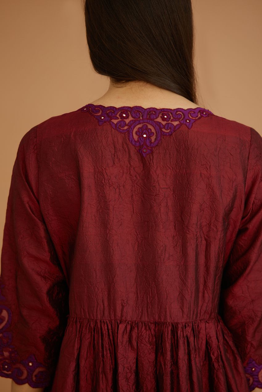 Maroon hand crushed silk kurta set with wavy empire waistline and gathers, with silk and organza cutwork embroidery, highlighted with hand attached mirrors.
