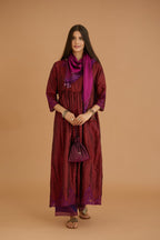Maroon hand crushed silk kurta set with wavy empire waistline and gathers, with silk and organza cutwork embroidery, highlighted with hand attached mirrors.