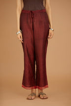 Maroon hand crushed silk pants with hand block print fine stripes and organza fabric and embroidery detail at bottom hem.