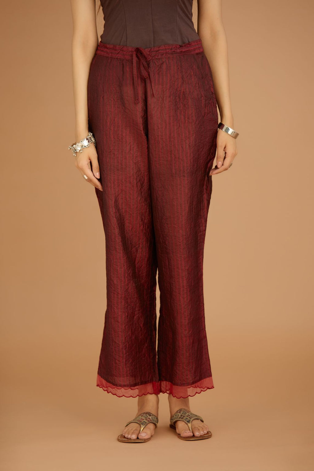 Maroon hand crushed silk pants with hand block print fine stripes and organza fabric and embroidery detail at bottom hem.