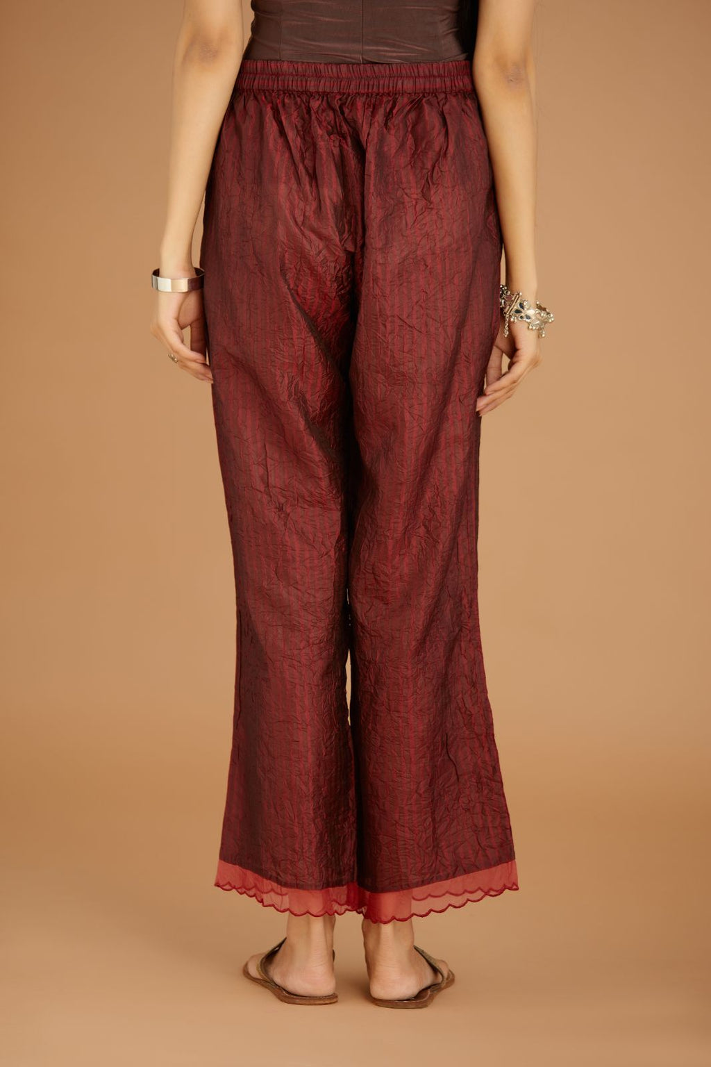 Maroon hand crushed silk pants with hand block print fine stripes and organza fabric and embroidery detail at bottom hem.