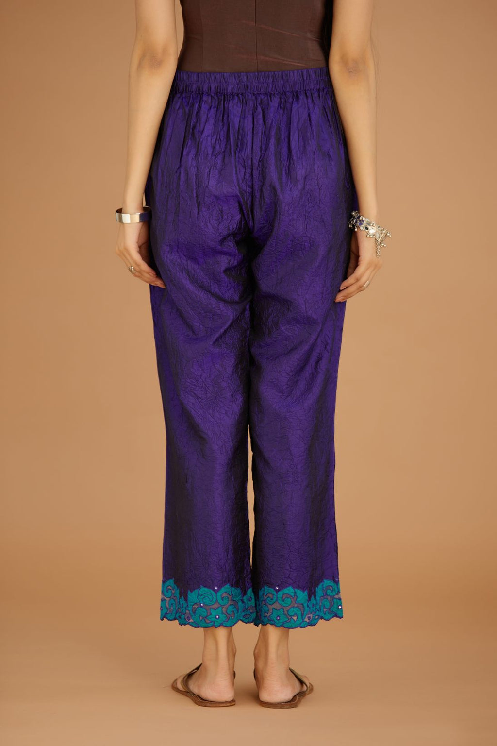 Blue hand crushed silk pants with contrast silk and organza fabric cutwork embroidery at bottom hem, highlighted with hand attached mirrors.