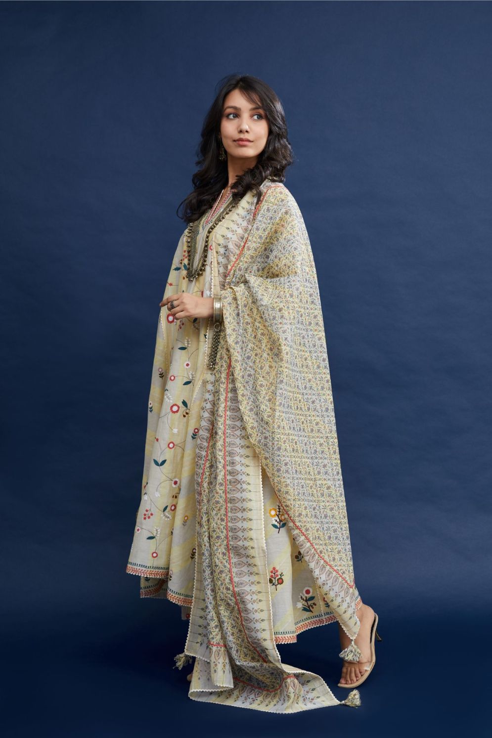 Beige hand block printed cotton Chanderi kurta set with asymmetric hem, highlighted with multi colored thread embroidery and ric-rac.