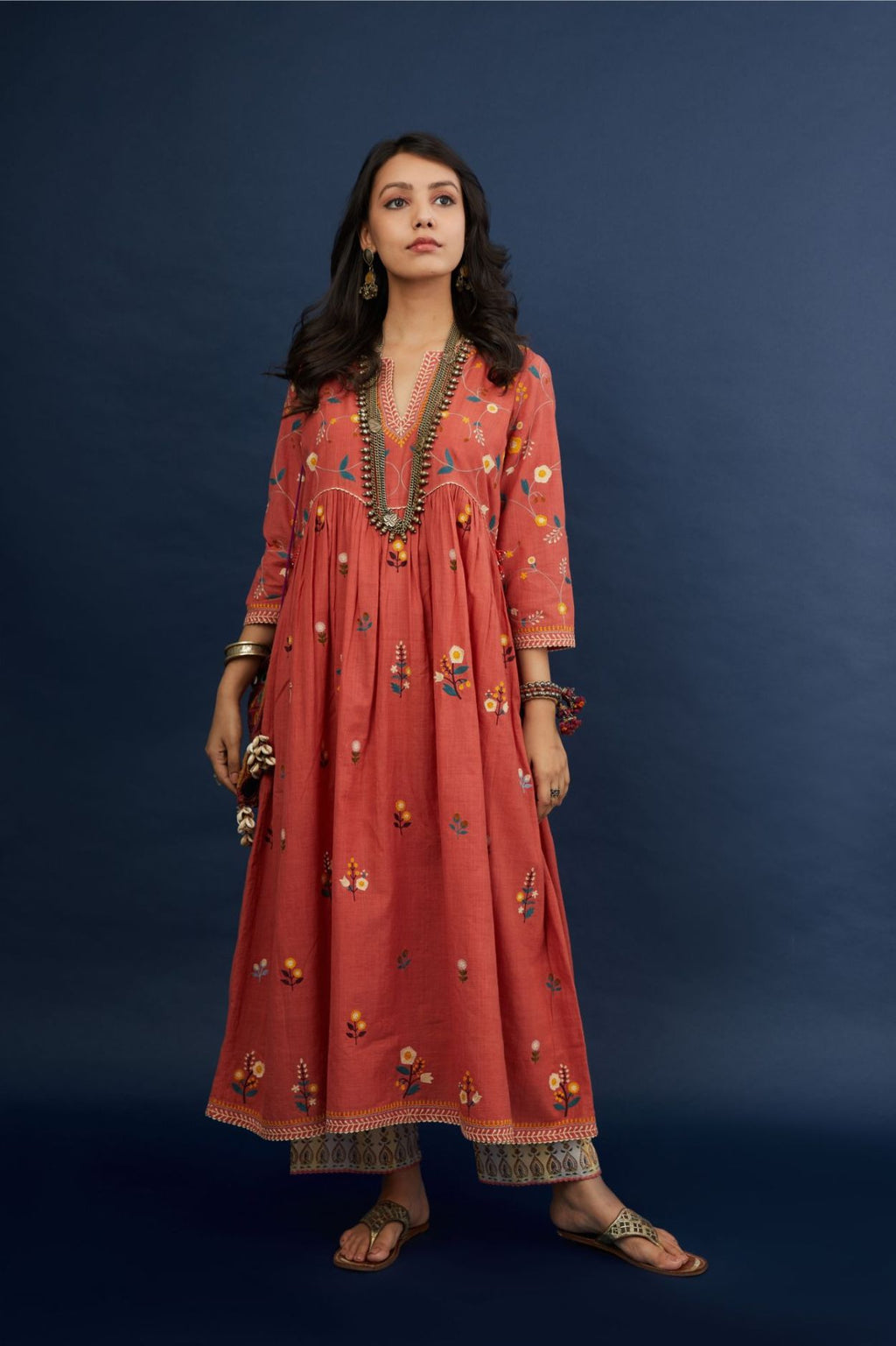Handspun hand-woven cotton kurta with wavy empire waistline and gathers, highlighted with all-over multi colored thread embroidery, paired with Hand block printed cotton pants with ric-rac detailing at hem