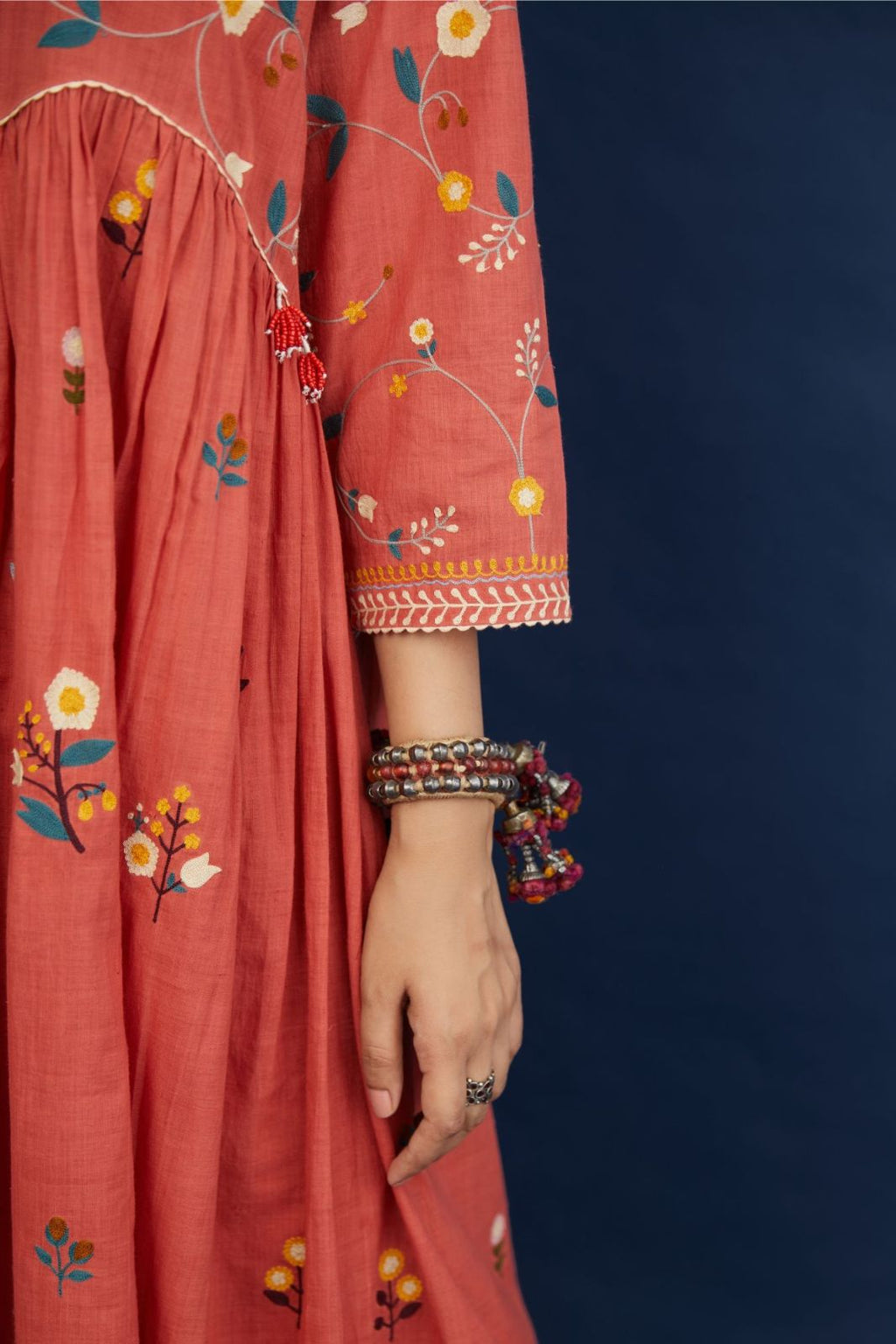 Handspun hand-woven cotton kurta with wavy empire waistline and gathers, highlighted with all-over multi colored thread embroidery, paired with Hand block printed cotton pants with ric-rac detailing at hem