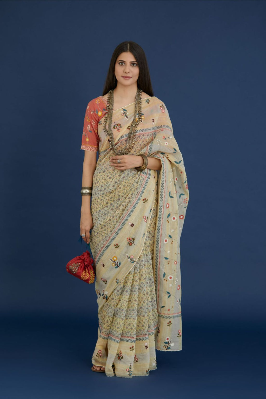 Beige hand block printed cotton Chanderi saree with all-over multi colored thread embroidery and fabric tassels.