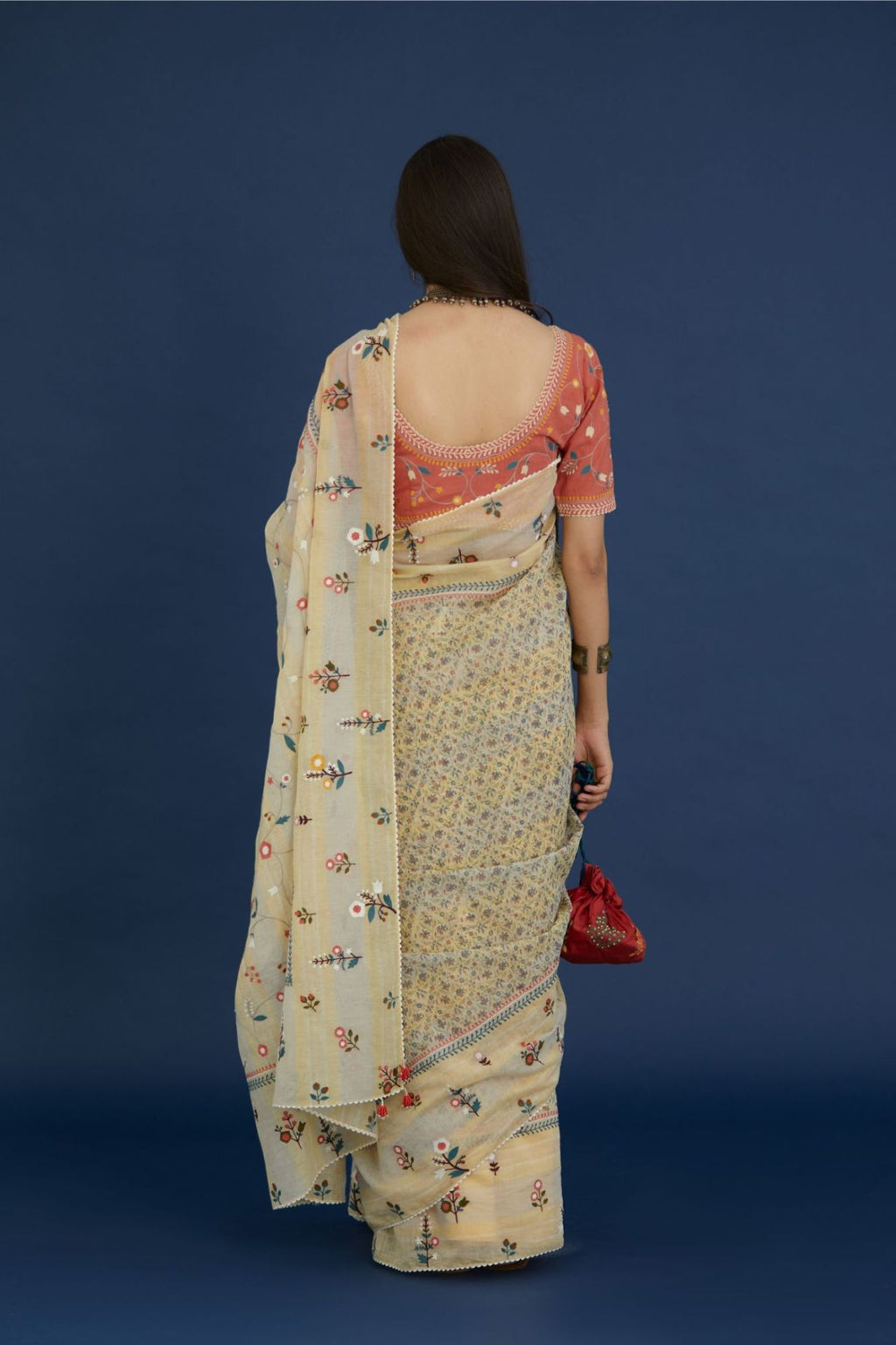 Beige hand block printed cotton Chanderi saree with all-over multi colored thread embroidery and fabric tassels.
