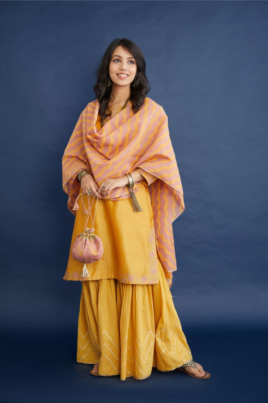 Golden yellow short kurta set highlighted with dull gold zari and contrast thread embroidery.