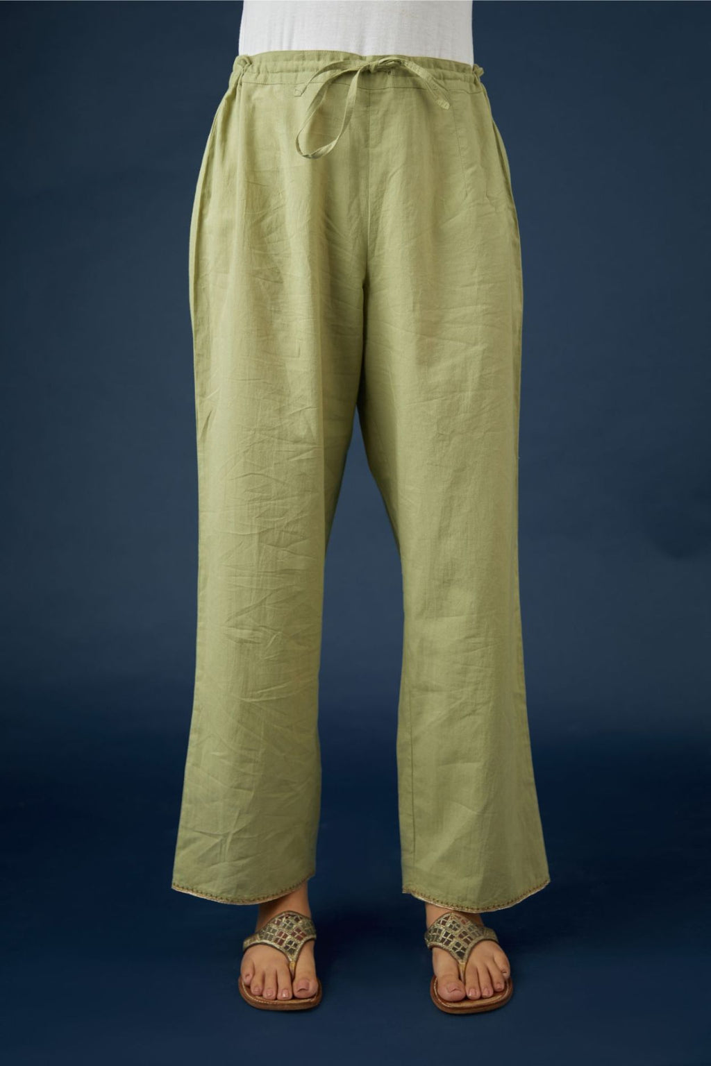 Green cotton straight pants with dull gold zari embroidery detailing at bottom hem. (Pants)