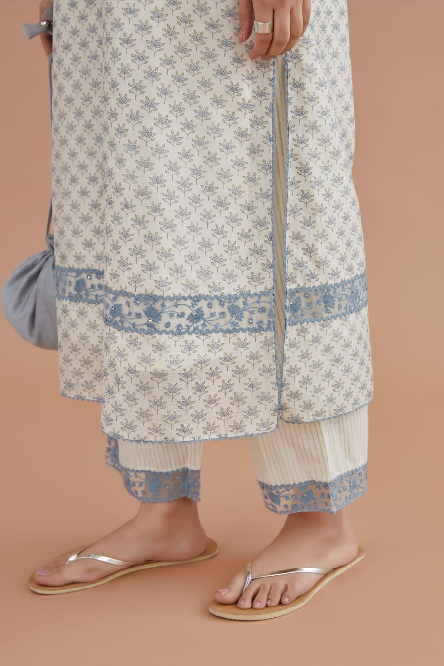 Off white silk chander kurta set with blue lotus hand block print, highlighted with blue thread embroidery inset and rickrack lace