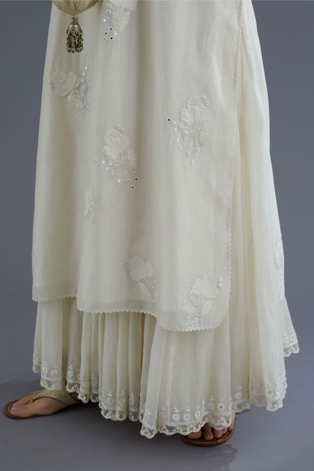Off white silk chanderi kurta set with applique flower embroidery and lace detailing at neck and side slits