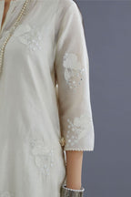 Off white silk chanderi kurta set with applique flower embroidery and lace detailing at neck and side slits