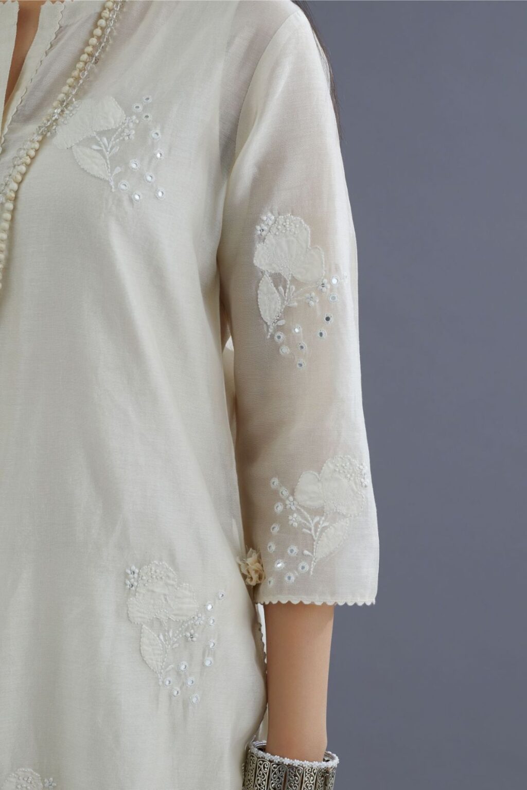 Off white silk chanderi kurta set with applique flower embroidery and lace detailing at neck and side slits