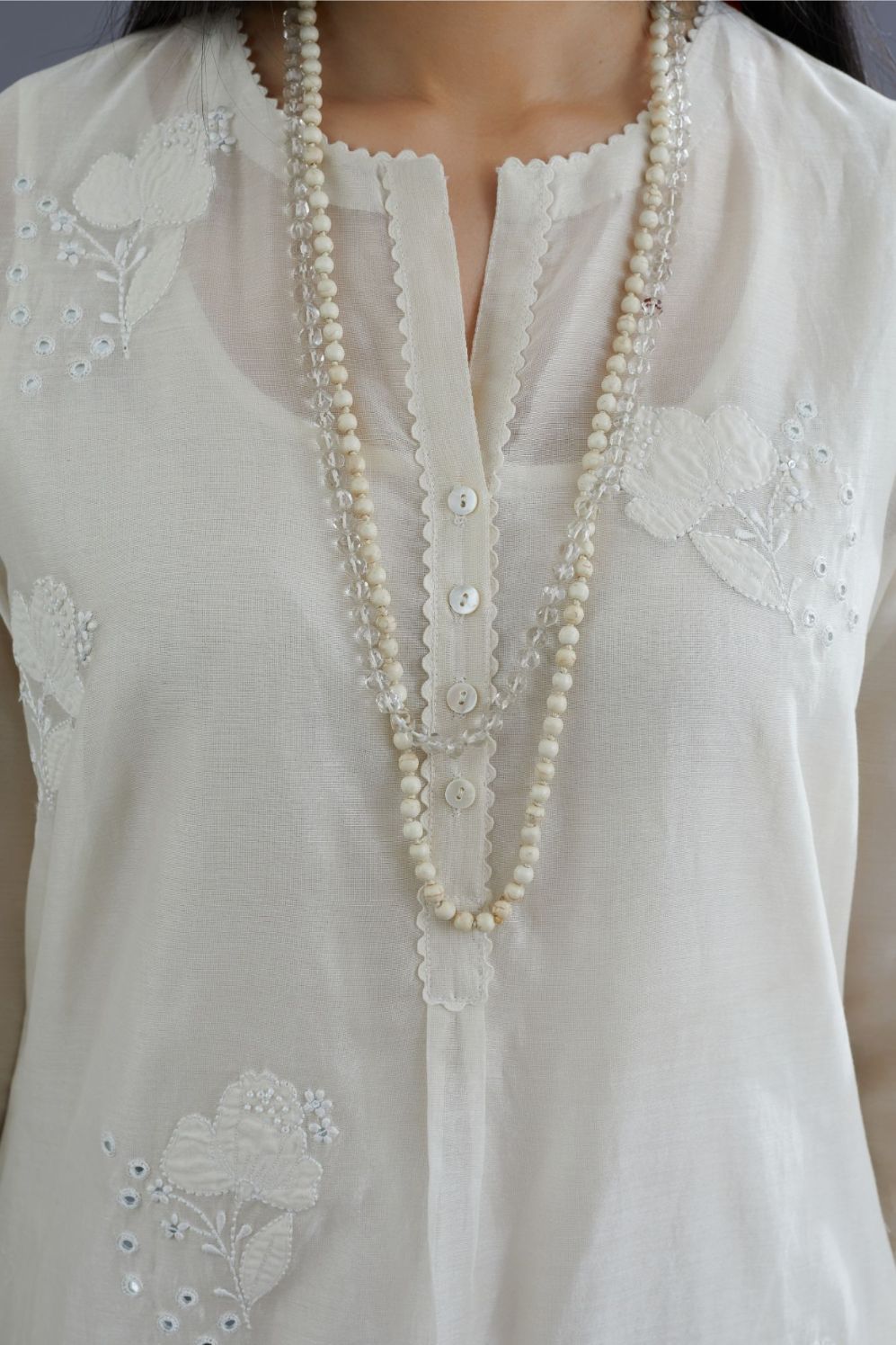 Off white silk chanderi kurta set with applique flower embroidery and lace detailing at neck and side slits