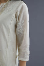 Off white silk chanderi kurta set with raised flower embroidery, highlighted with mirror hand work and beads
