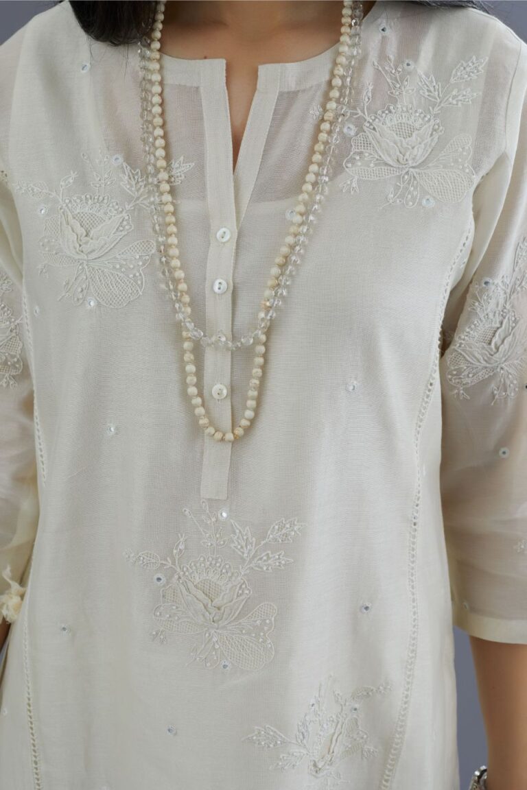Off white silk chanderi kurta set with raised flower embroidery, highlighted with mirror hand work and beads