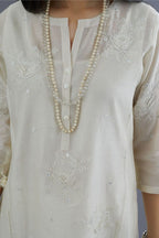 Off white silk chanderi kurta set with raised flower embroidery, highlighted with mirror hand work and beads