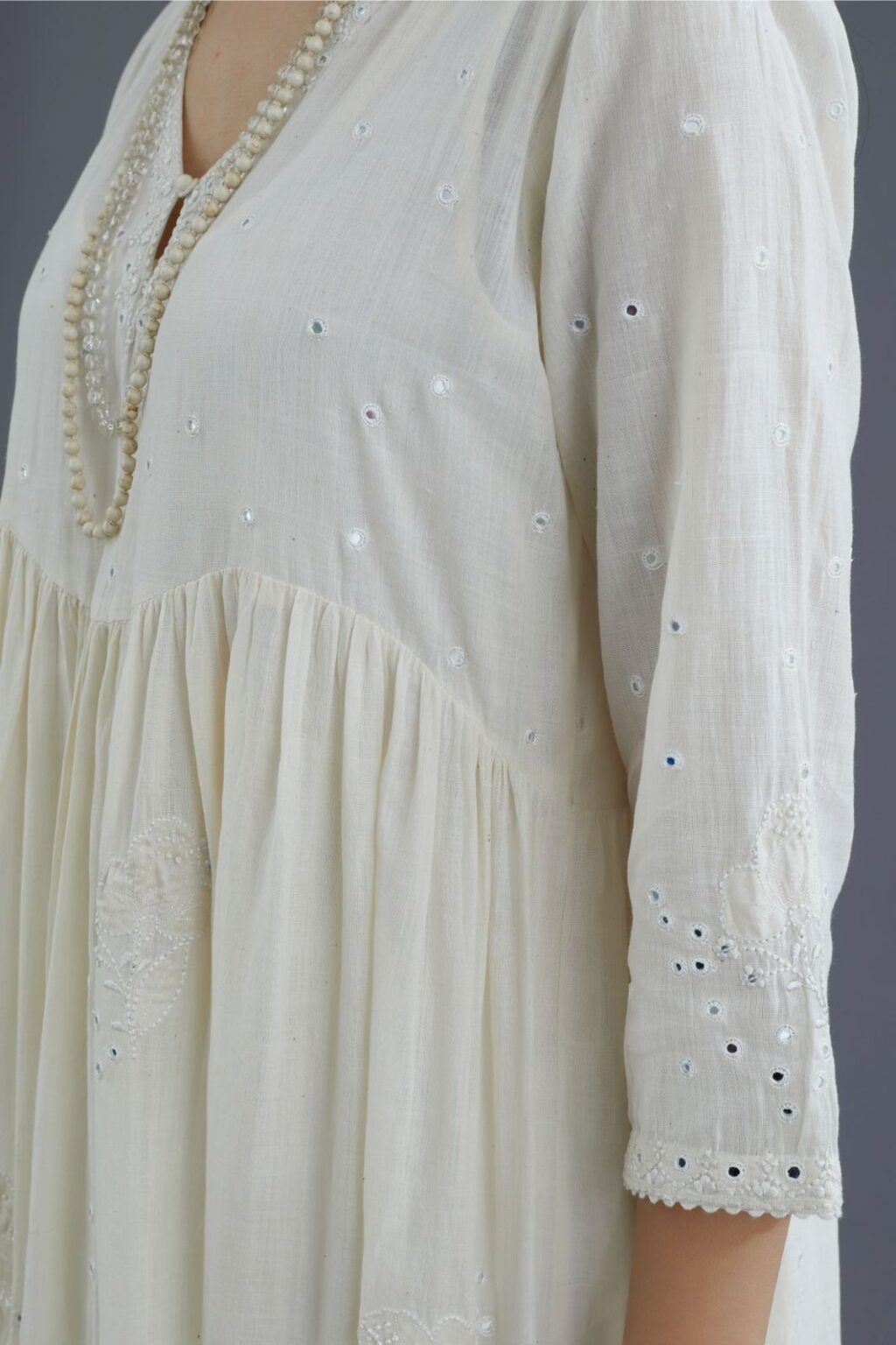 Handspun Hand-Woven cotton kurta set with wavy empire waistline and gathers, highlighted with applique flower embroidery and mirror hand work