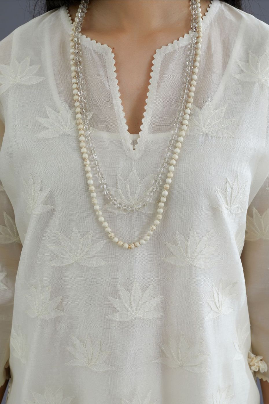 Off white chanderi kurta set with all-over applique flower embroidery and lace detailing at neck and side slits