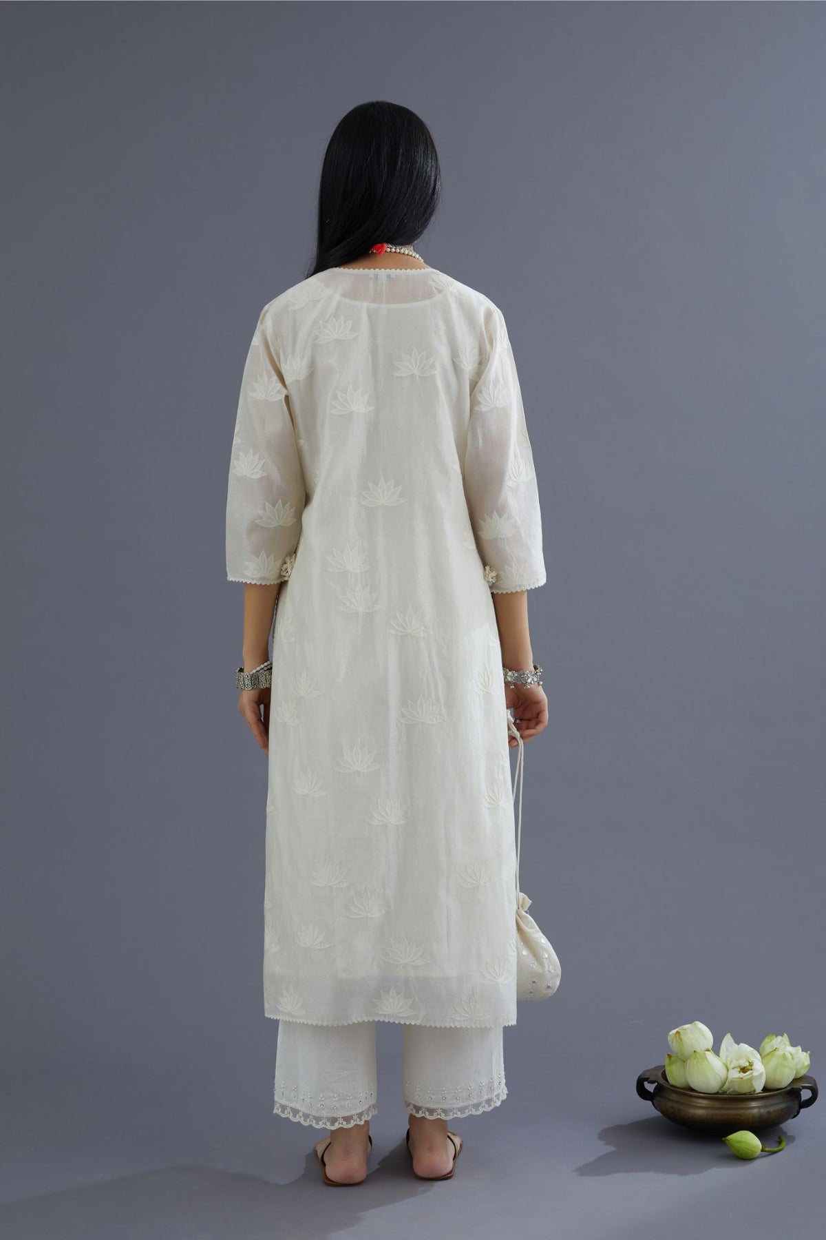 Off white silk chanderi kurta set with all-over applique lotus flower embroidery and lace detailing at neck and side slits