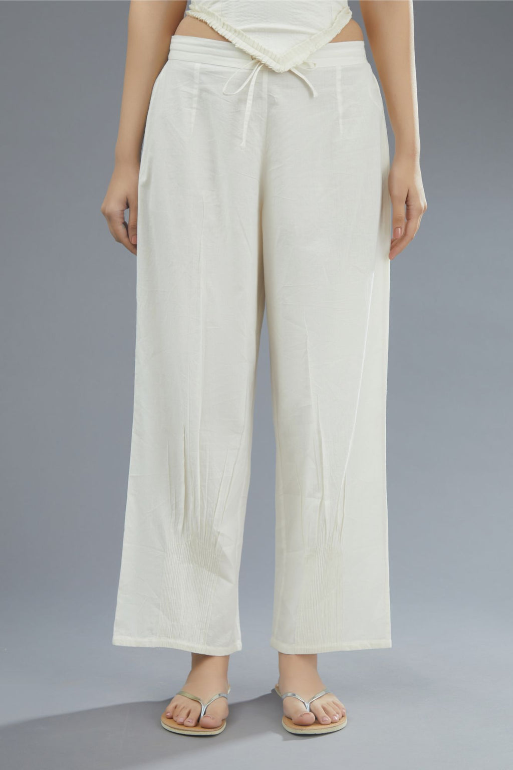 Off white straight pants detailed with pintucks at bottom.