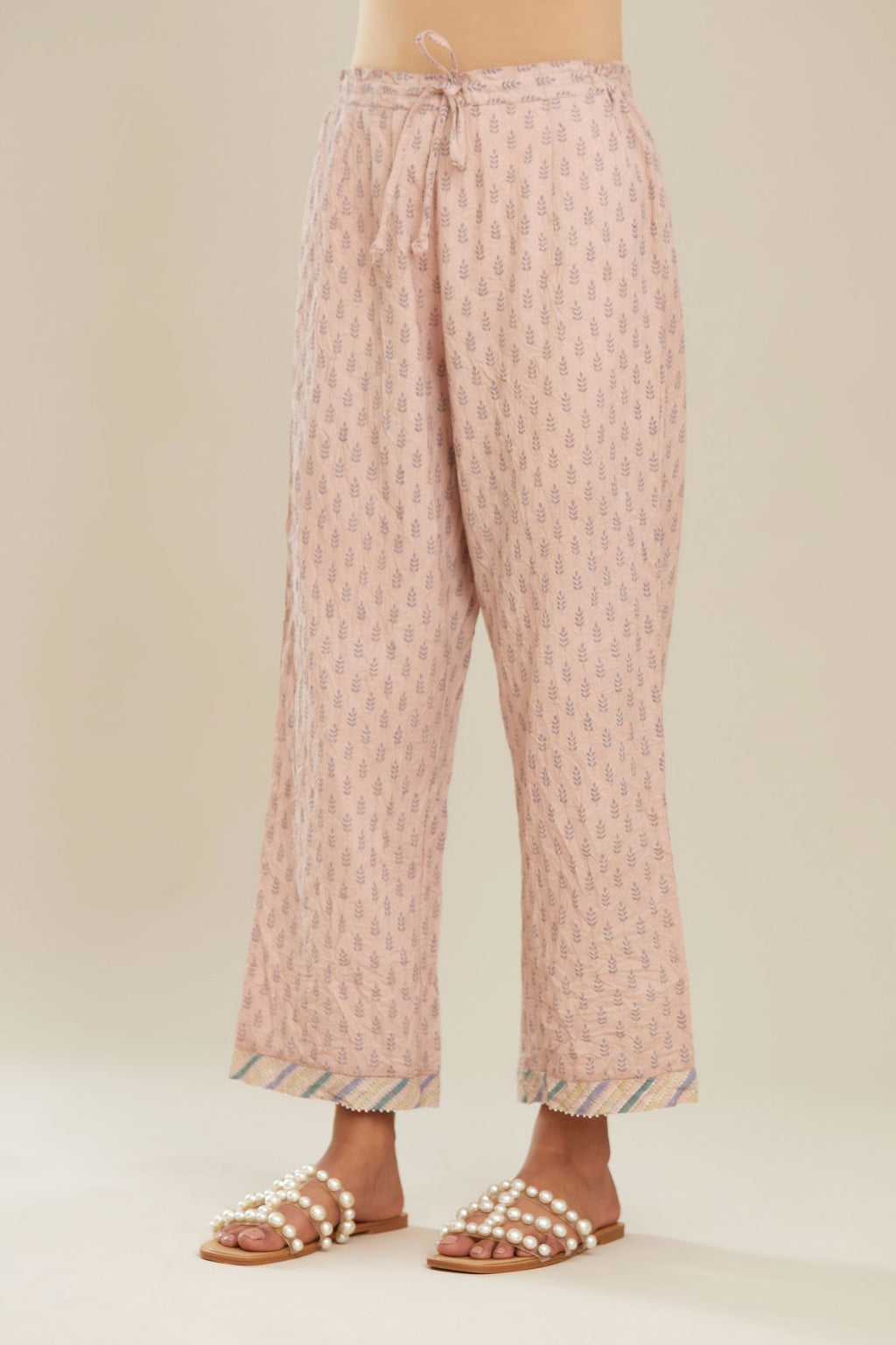 Pink hand block printed straight pants with striped fabric attached at bottom with faggoting and highlighted with hand attached beads. (PANTS)