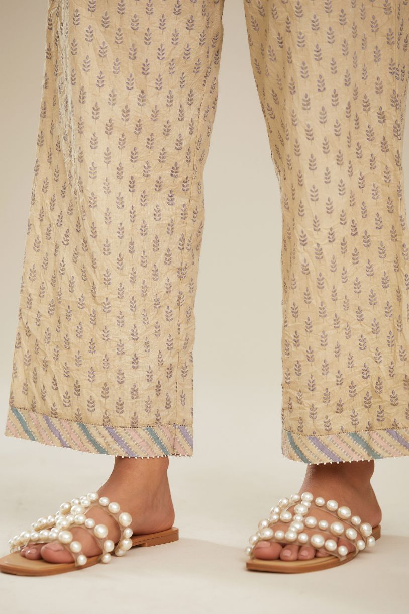 Beige hand block printed straight pants with striped fabric attached at bottom with faggoting and highlighted with hand attached beads. (PANTS)