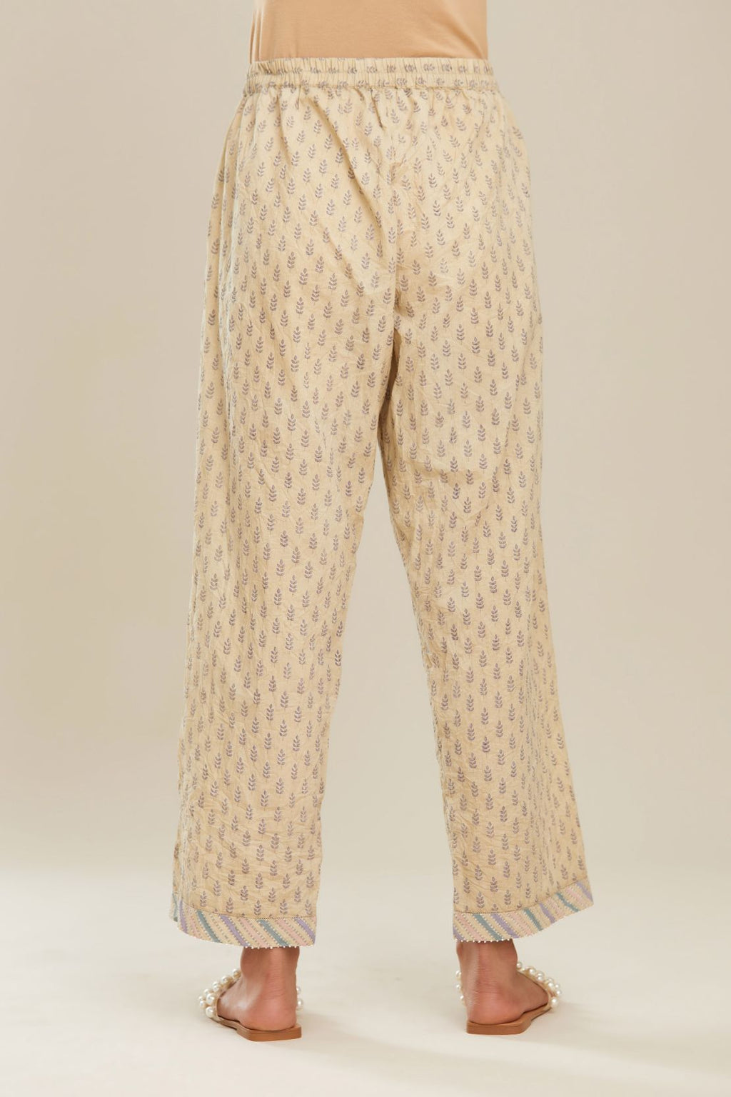 Beige hand block printed straight pants with striped fabric attached at bottom with faggoting and highlighted with hand attached beads. (PANTS)