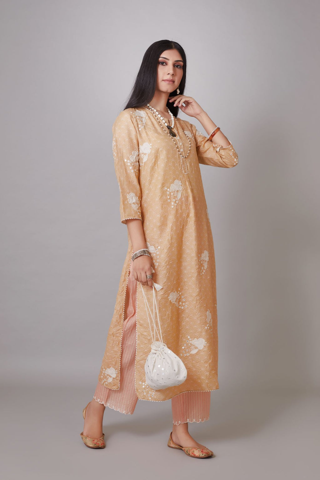 Peach hand block printed crushed silk kurta set with applique flower embroidery and lace detailing at neck and side slits.