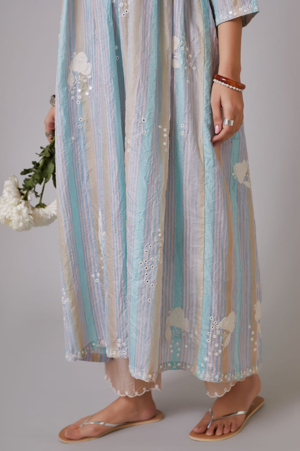 Multi striped hand-crushed silk kurta set with wavy empire waistline and gathers, highlighted with applique flower embroidery and mirror hand work.